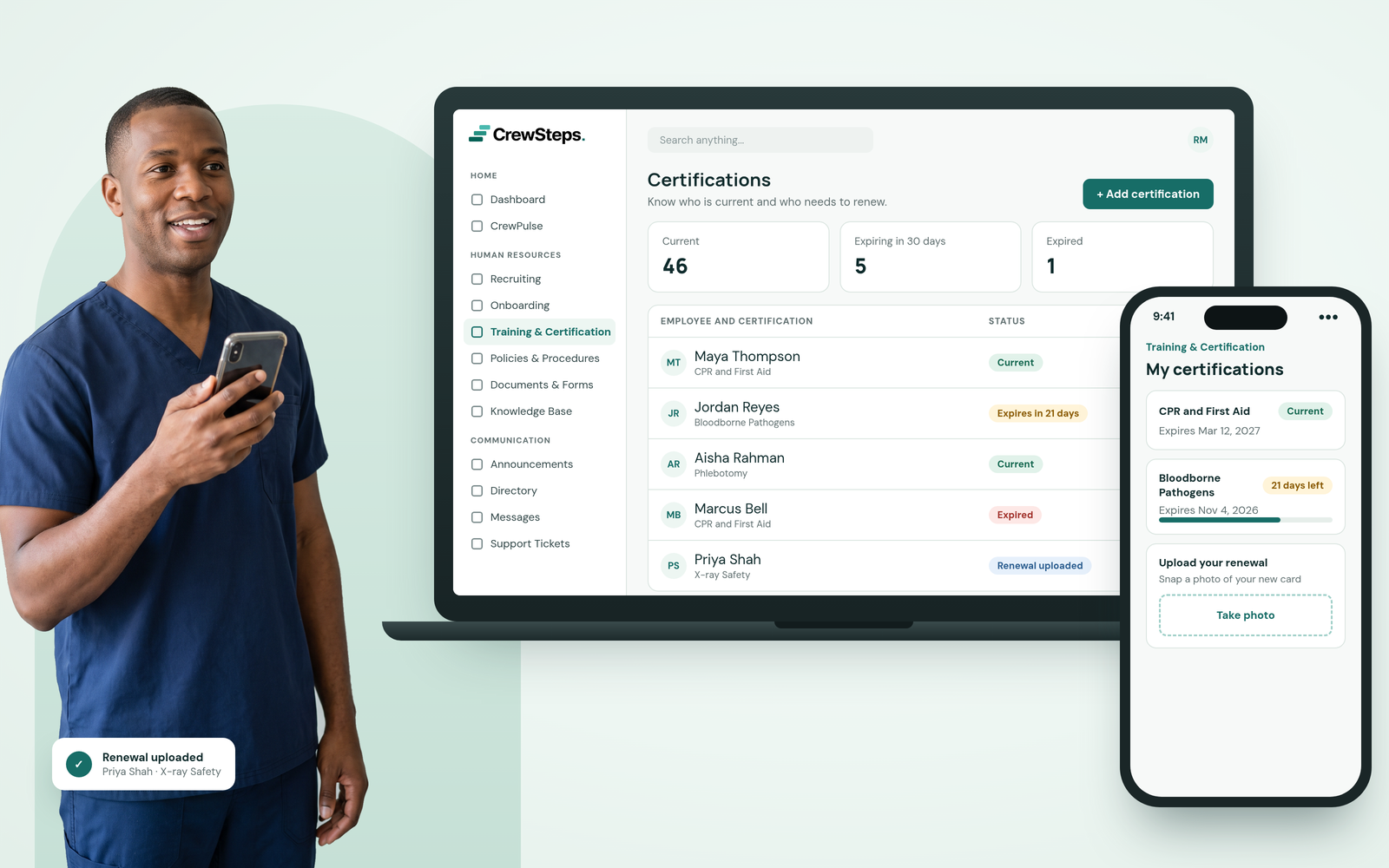 A smiling clinic nurse in navy scrubs holding his phone beside a CrewSteps laptop tracking staff certifications and a phone showing his own certifications with a renewal upload.